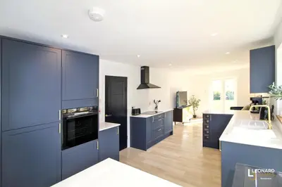 a large kitchen with blue cabinets and a sink at Bright & Stylish Bungalow Retreat in Attleborough in Attleborough