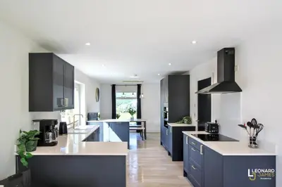 a kitchen with blue cabinets and white counter tops at Bright & Stylish Bungalow Retreat in Attleborough in Attleborough
