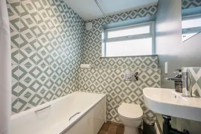 a bathroom with a tub and a toilet and a sink at 1 Leiston Court, Leiston in Leiston
