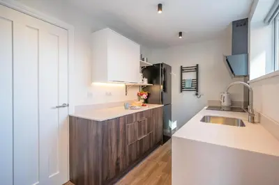 a kitchen with white cabinets and a sink at 1 Leiston Court, Leiston in Leiston