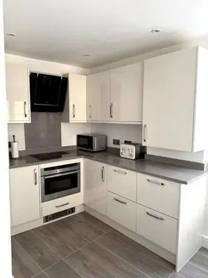 a white kitchen with white cabinets and a microwave at Cosy Central Colchester Home by Castle Park in Colchester