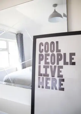a sign that says cool people live here in a room at Bright & Airy 4x Bed House with Parking in Ely
