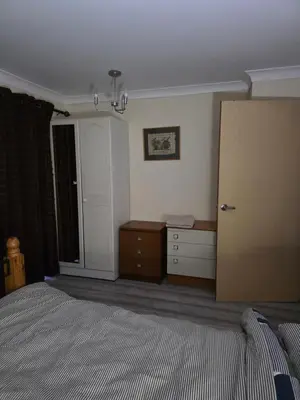 a bedroom with a bed and a dresser and a door at Cosy in Colchester x5 in Hythe