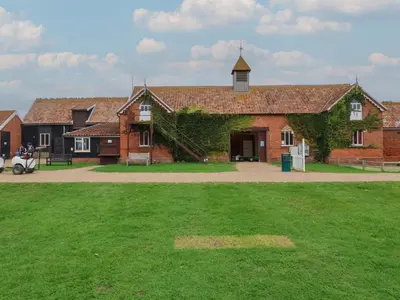 a large brick building with ivy growing on it at Carabelle Cow Shed 7 in Woodbridge