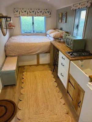 a small room with two beds and a desk at Shepherds hut in Holywell Cambridgeshire in Holywell