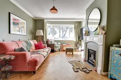 a living room with a red couch and a fireplace at Charming 4 bedroom home in Felsted in Felsted