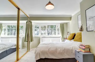 a bedroom with a bed and two windows at Charming 4 bedroom home in Felsted in Felsted