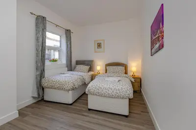 a bedroom with two beds and a window at Coral Bay Seaside Aparto in Clacton-on-Sea