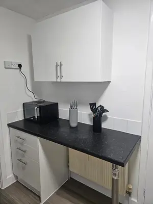 a black counter in a kitchen with a microwave at Coral Bay Seaside Aparto in Clacton-on-Sea