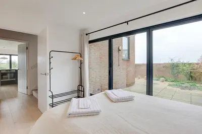 a bedroom with a bed and a large window at Two bedroom house with far-reaching country views in Sheering