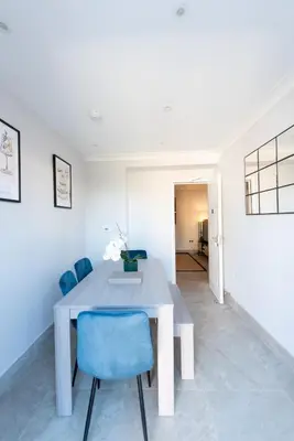 a white dining room with a table and blue chairs at 4 Bedroom Home - 2 Mins to Town CM7 - Contractor Ready in Braintree