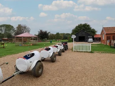 a row of white cars parked next to a park at Duchess Cottage in Woodbridge