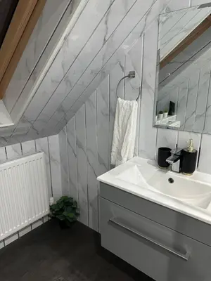 a bathroom with a sink and a mirror at A Cosy and Spacious Studio Flat in Navestock