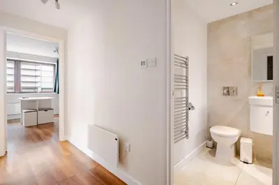 a white bathroom with a toilet and a sink at Chic escape in Cambridge