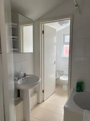 a white bathroom with a sink and a toilet at 2 Willow Cottage in Takeley