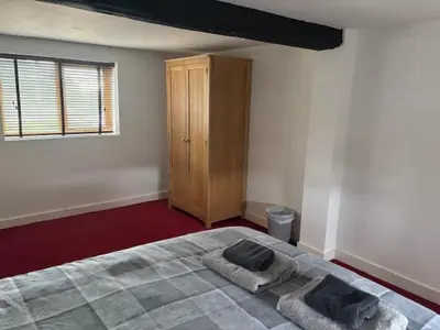 a bedroom with a bed with two towels on it at 2 Willow Cottage in Takeley