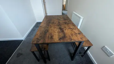 a wooden table in the corner of a room at Harlech House Flats in Clacton-on-Sea
