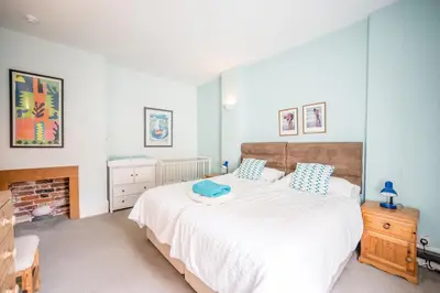 a bedroom with a large white bed with blue pillows at Orlando, Aldeburgh in Aldeburgh