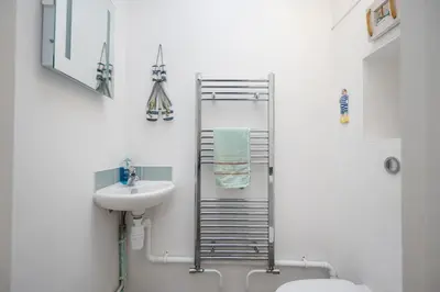 a bathroom with a sink and a toilet and a towel rack at Orlando, Aldeburgh in Aldeburgh