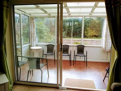 a screened in porch with chairs and a table at Bungalow in Cambridge- 3 bedrooms in CBG