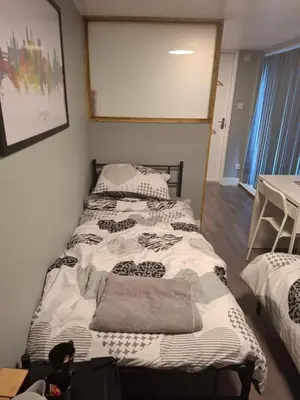 a bedroom with two beds and a table at Als air b and b in Cherry Hinton
