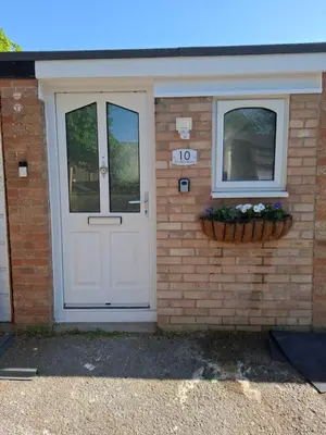 a brick house with a white door and two windows at Als air b and b in Cherry Hinton