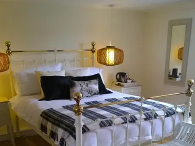a bedroom with a bed and a lamp and a mirror at Guest Rooms at The Green Man in Takeley