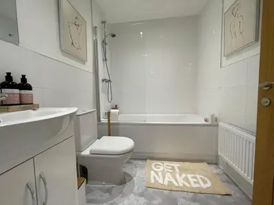 a bathroom with a toilet and a sink and a tub at Iris Cottage 4BR Coastal Retreat in Wenhaston
