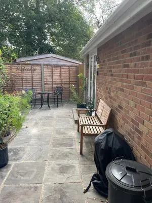 a patio with benches and a table and a fence at Woodland View in East Harling