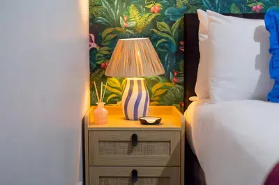 a lamp on a night stand next to a bed at Pass the Keys Ground Floor Apartment with Free Parking in Cambridge