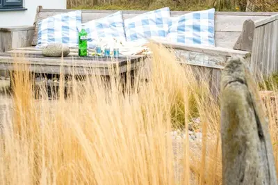 a wooden bench with a table in the grass at Chicoutimi 4 in Thorpeness