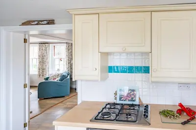 a kitchen with white cabinets and a stove top oven at Sanderlings 4 in Aldeburgh