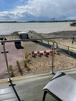 a balcony with a view of a beach and the water at Admirals in Shotley Gate