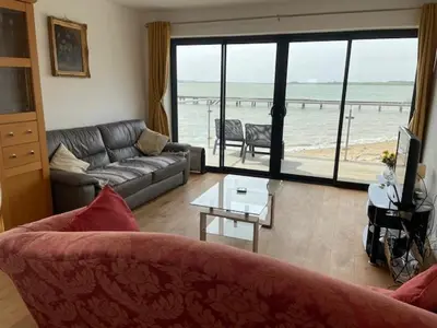 a living room with a couch and a view of the ocean at Admirals in Shotley Gate