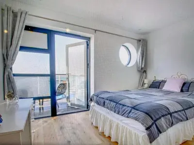 a bedroom with a bed and a large window at Admirals in Shotley Gate