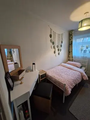 a bedroom with a bed and a desk and a mirror at The Green Box in Great Clacton