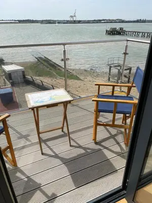 a deck with a table and chairs on the beach at Ten Admiralty Pier in Shotley Gate