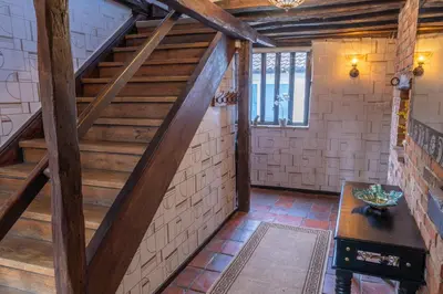 an attic hallway with stairs and a table at 3 Bed Country House with Pool and Sauna in Tibenham