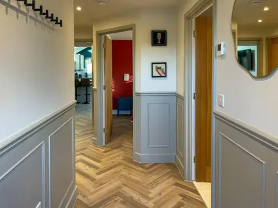 a hallway with wood floors and a mirror on the wall at Luxury 2 bed new-build house near Science & Business parks in Cambridge