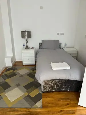 a bedroom with a bed and two night stands at Maxismile Haven in Southend-on-Sea