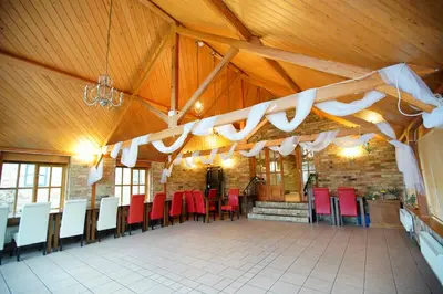 a large room with red and white chairs and tables at The Golden Boar Inn in Freckenham