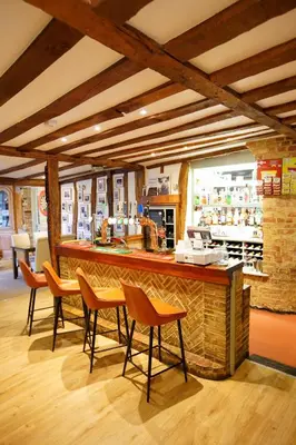 a restaurant with a bar with chairs and a counter at The Golden Boar Inn in Freckenham