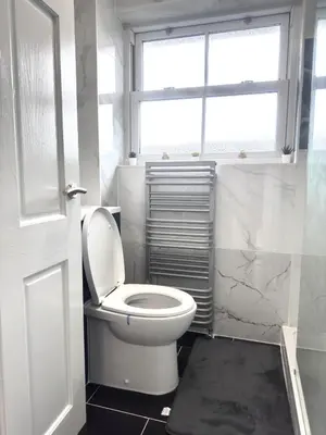 a bathroom with a white toilet and a window at Ama comfort Stay in Hythe
