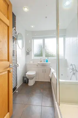 a bathroom with a toilet and a tub and a sink at Pass the Keys 3-Bedroom Home in Chelmsford Sleeps 7 in Chelmsford