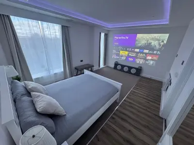 a bedroom with a large bed and a large window at Cinema room apartment 1 in Basildon