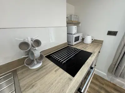 a kitchen with a counter top with a microwave at Cinema room apartment 1 in Basildon