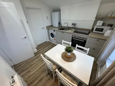 a kitchen with a table and chairs in a kitchen at Cinema room apartment 1 in Basildon