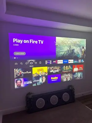 a tv with a large screen on a wall at Cinema room apartment 1 in Basildon