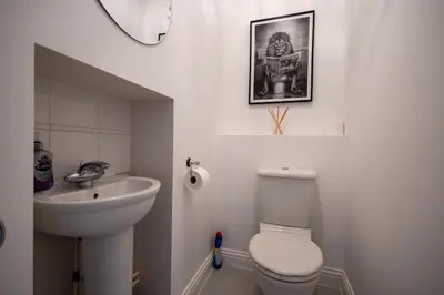 a white bathroom with a toilet and a sink at Brook - Sizewell - Contractor Accommodation in Saxmundham
