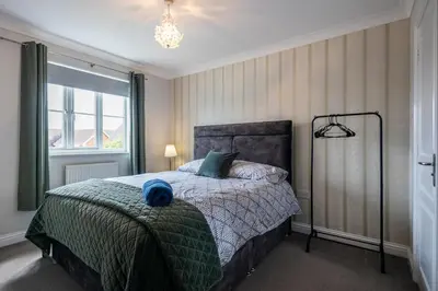 a bedroom with a bed and a large window at Brook - Sizewell - Contractor Accommodation in Saxmundham
